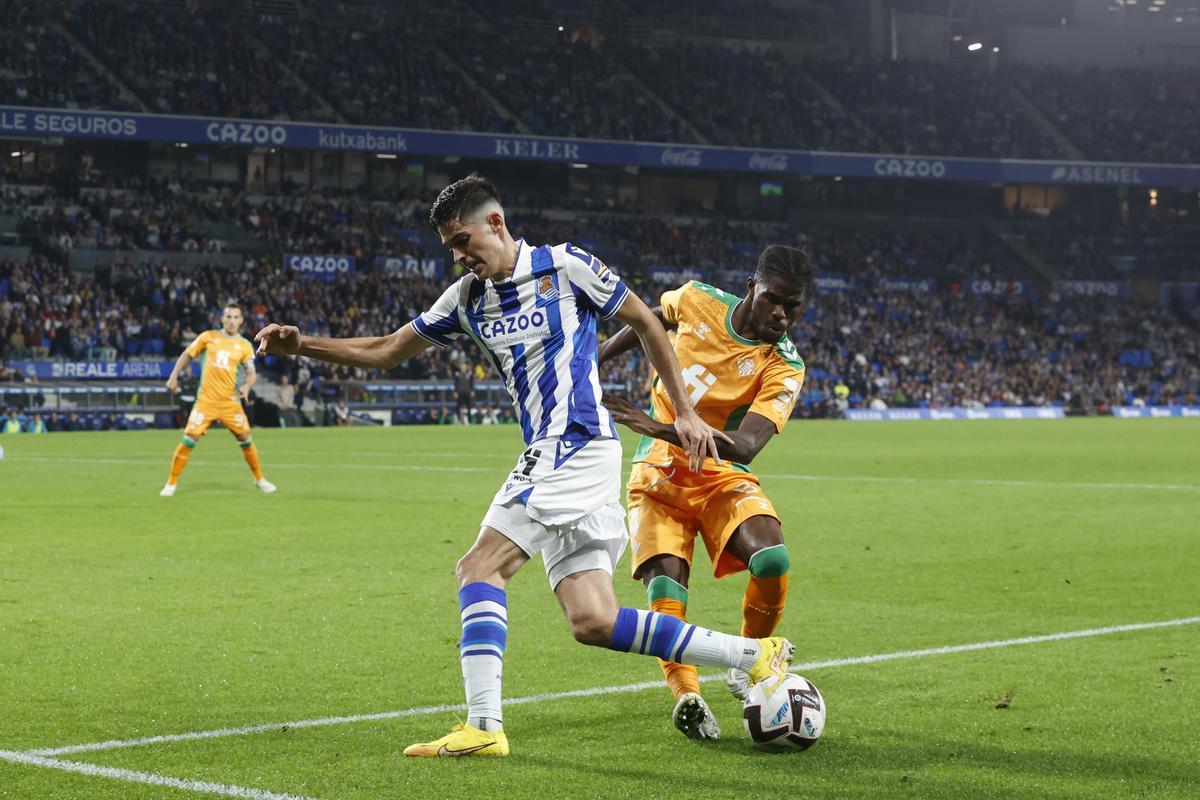 SAN SEBASTIÁN, 30/10/2022.- El delantero de la Real Sociedad Carlos Fernández (i) lucha con el marfileño Paul Akouokou, del Real Betis, durante el partido de la jornada 12 de LaLiga que Real Sociedad y Real Betis disputan este domingo en el Reale Arena, en San Sebastián. EFE/Javier Etxezarreta