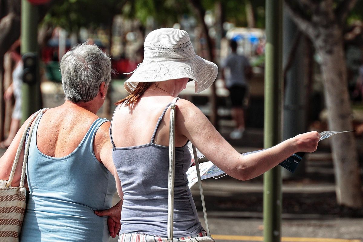 Two women stroll under the harsh sun of Santa Cruz.