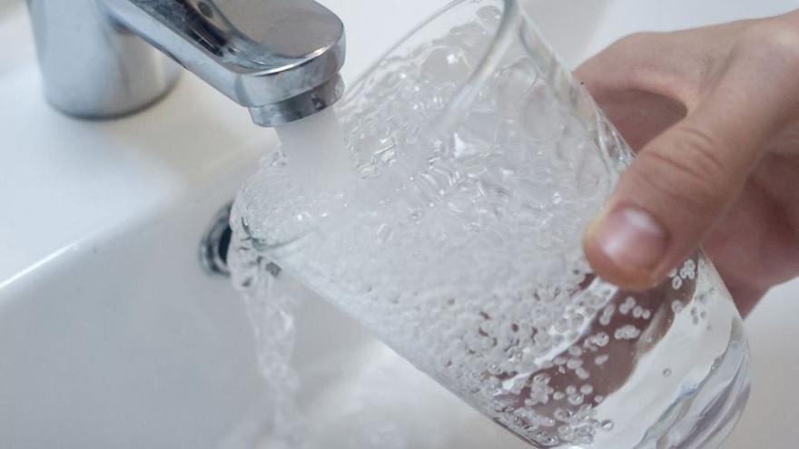 Persona llenando un vaso de agua en una casa. | R. Rubio/E. Press