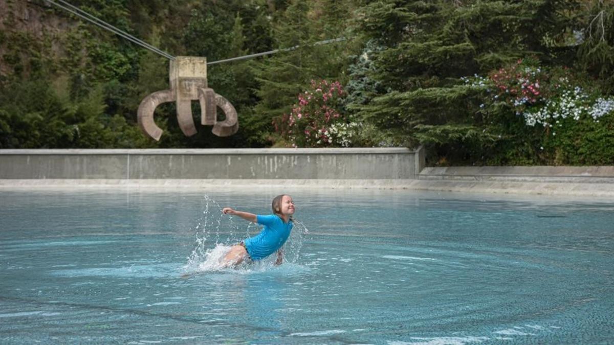 Una niña se refresca en el parc de la Creueta, en Barcelona