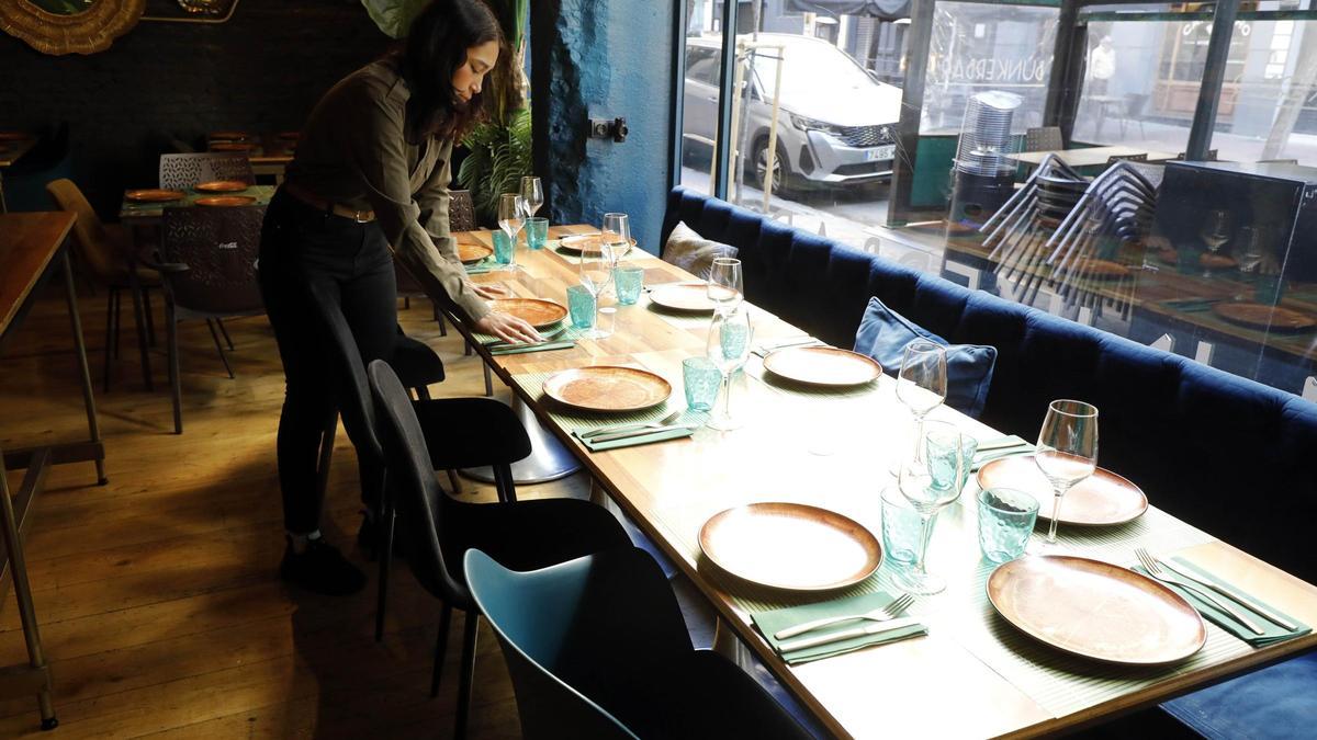 Una trabajadora del restaurante Bunkerbar de Zaragoza prepara una mesa reservada, este fin de semana.