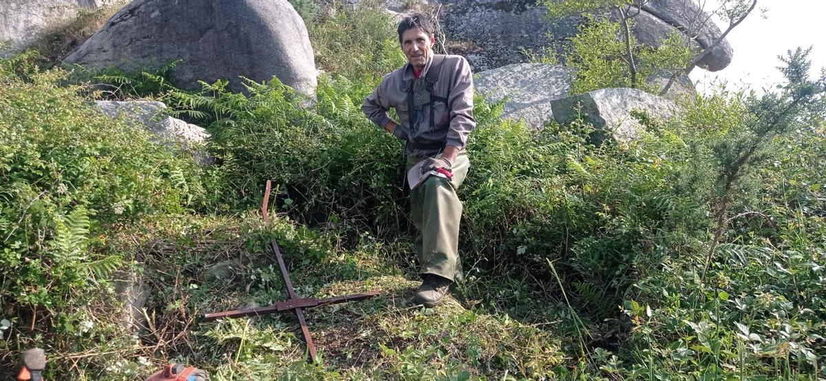 Uno de los operarios que encontró la cruz, tirada entre la maleza a los pies del mirador.