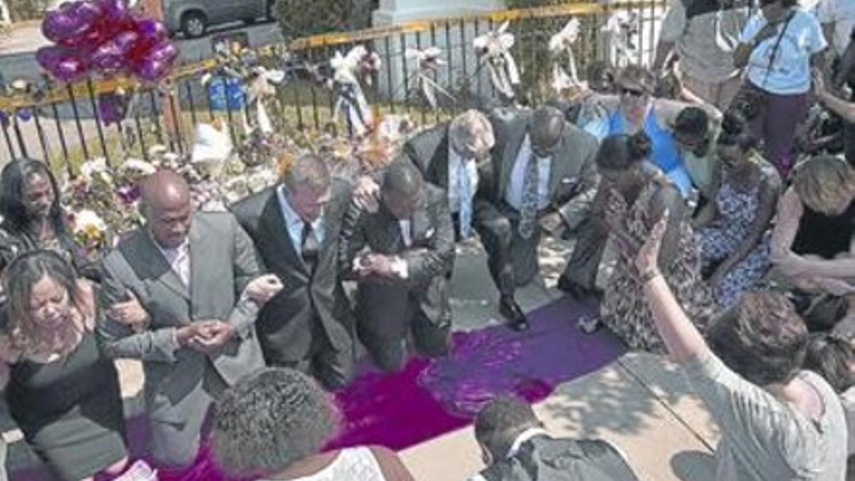 Pregaria colectiva en las afueras de la iglesia de Charleston donde hubo el tiroteo