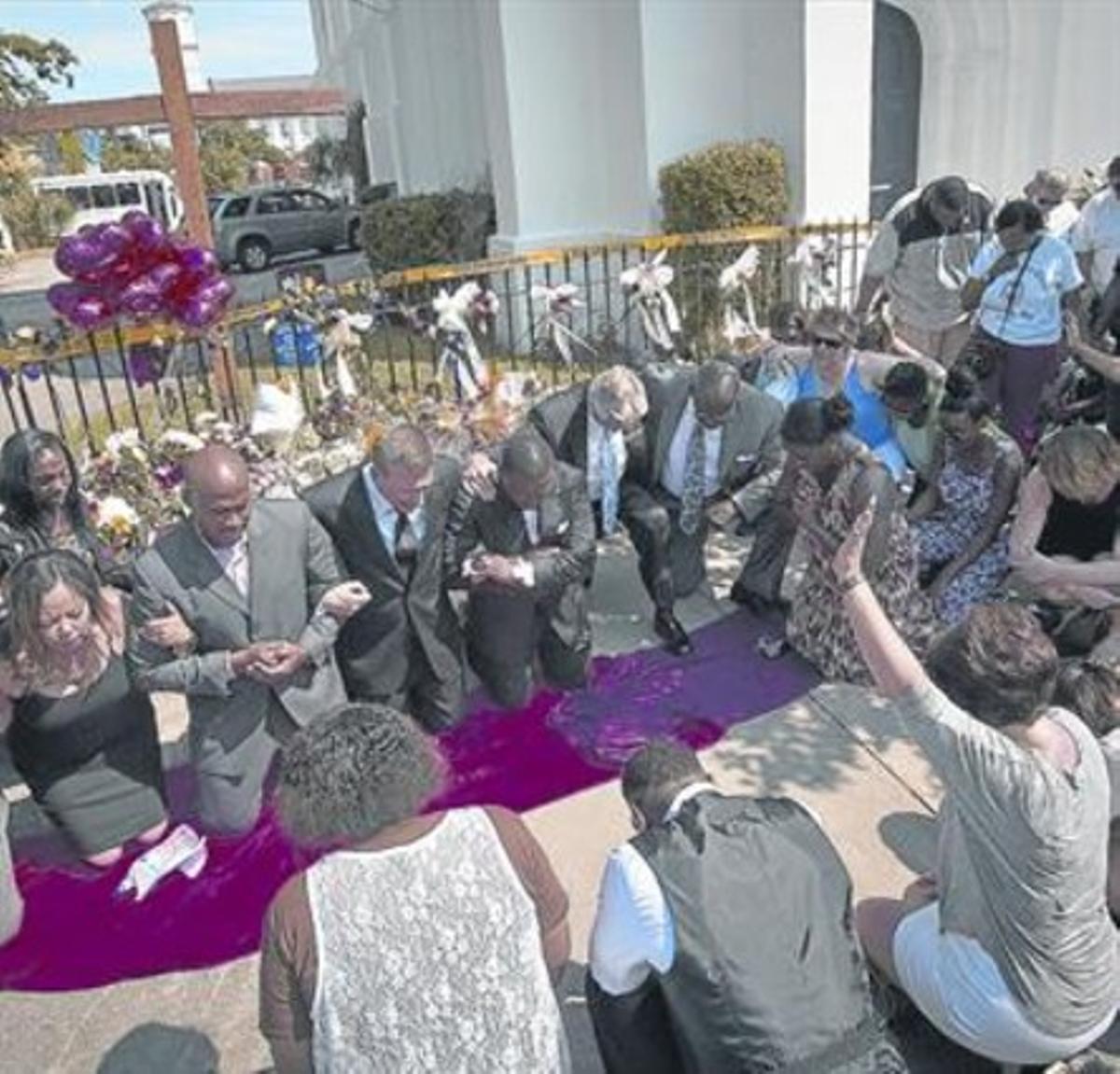 Pregaria colectiva en las afueras de la iglesia de Charleston donde hubo el tiroteo