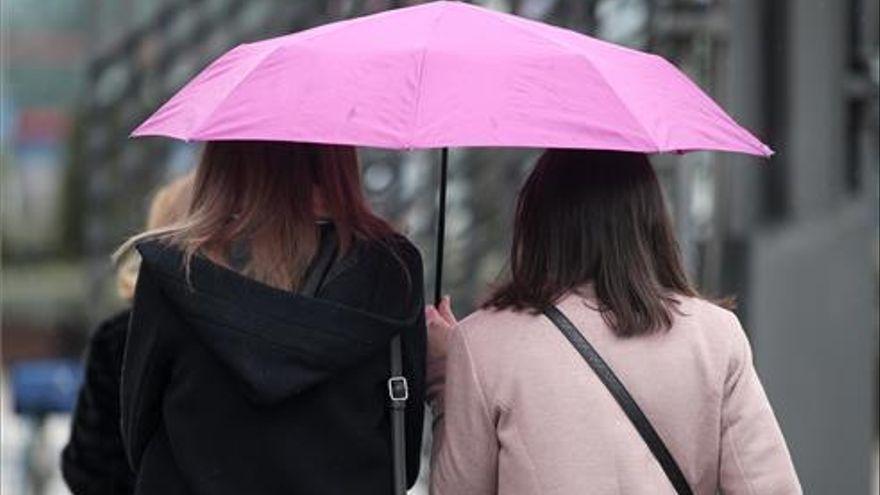 Dos ciudadanas se protegen de la lluvia con un paraguas.