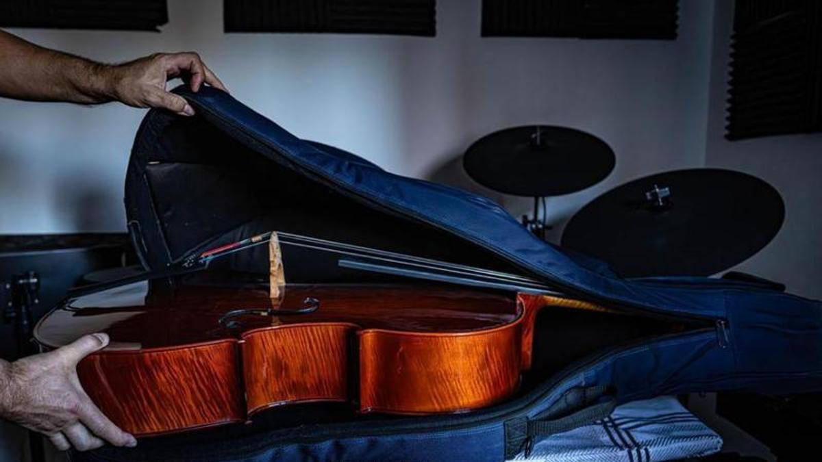 Un home guarda un violoncel en la seva funda