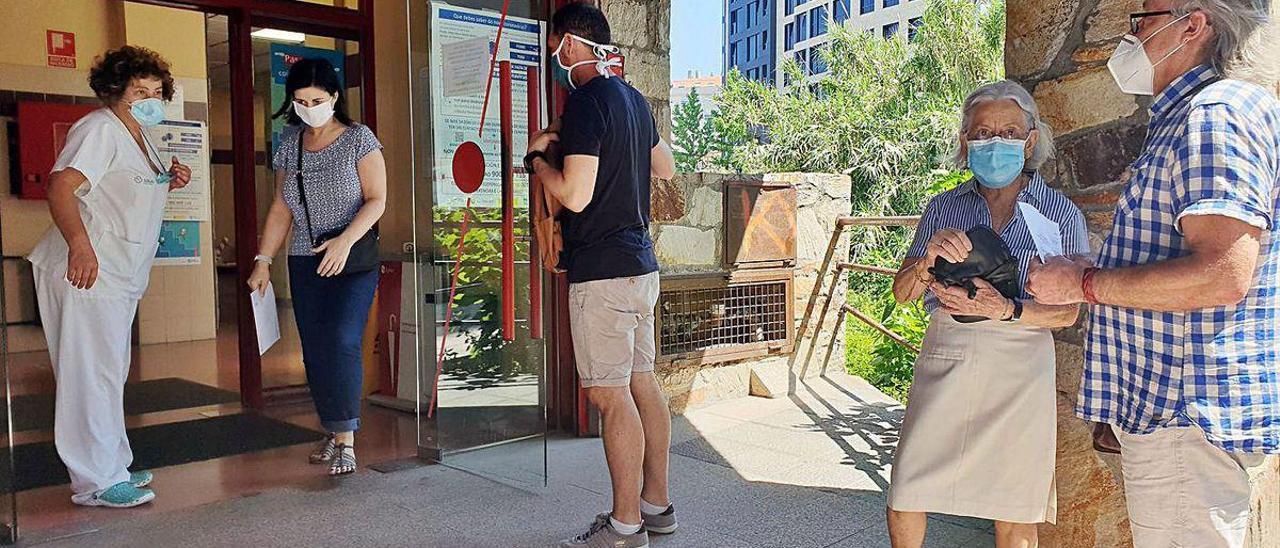 Gente haciendo cola en el exterior de un centro de salud.