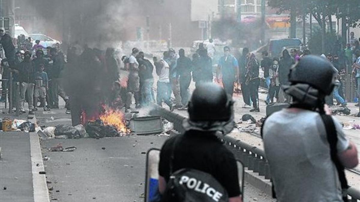 Batalla campal 8 Policías antidisturbios ante los manifetantes en el barrio de Sarcelles, ayer.