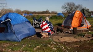 Una persona homeless envuelta en una bandera de EEUU en un campamento en Sacramento, California