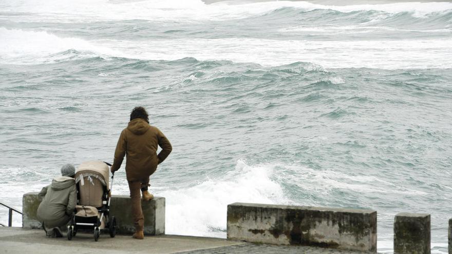 Dos jóvenes observan el oleaje, ayer, en A Coruña. // Víctor Echave