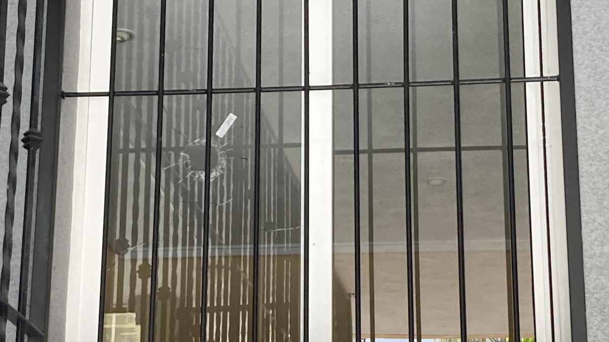 Impacto de bala en una de las ventandas del rellano del edificio