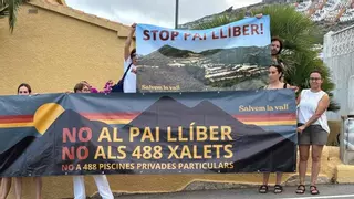 Activistas de Salvem la Vall se plantan con carteles contra el PAI de Llíber de 488 casas en la fiesta de la promotora
