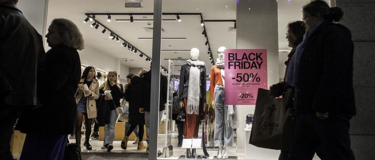 Viandantes pasean frente a una de las tiendas de moda de Príncipe (Vigo).