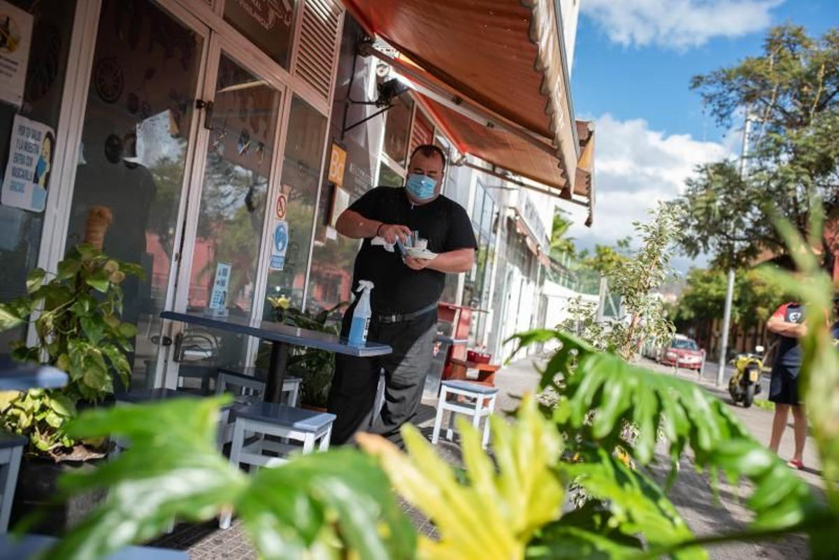 Un camarero prepara una mesa para sus próximos clientes.