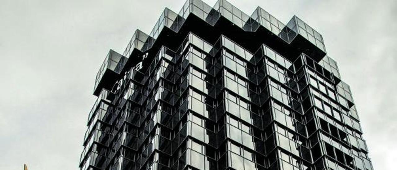 Una joven pasa por delante del edificio de CaixaBank en Barcelona.