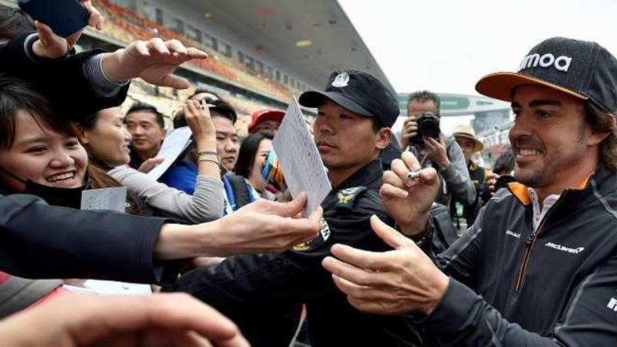 Alonso firma autógrafos entre aficionados.