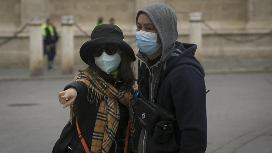 Dos turistas con mascarillas pasean por el centro de Sevilla