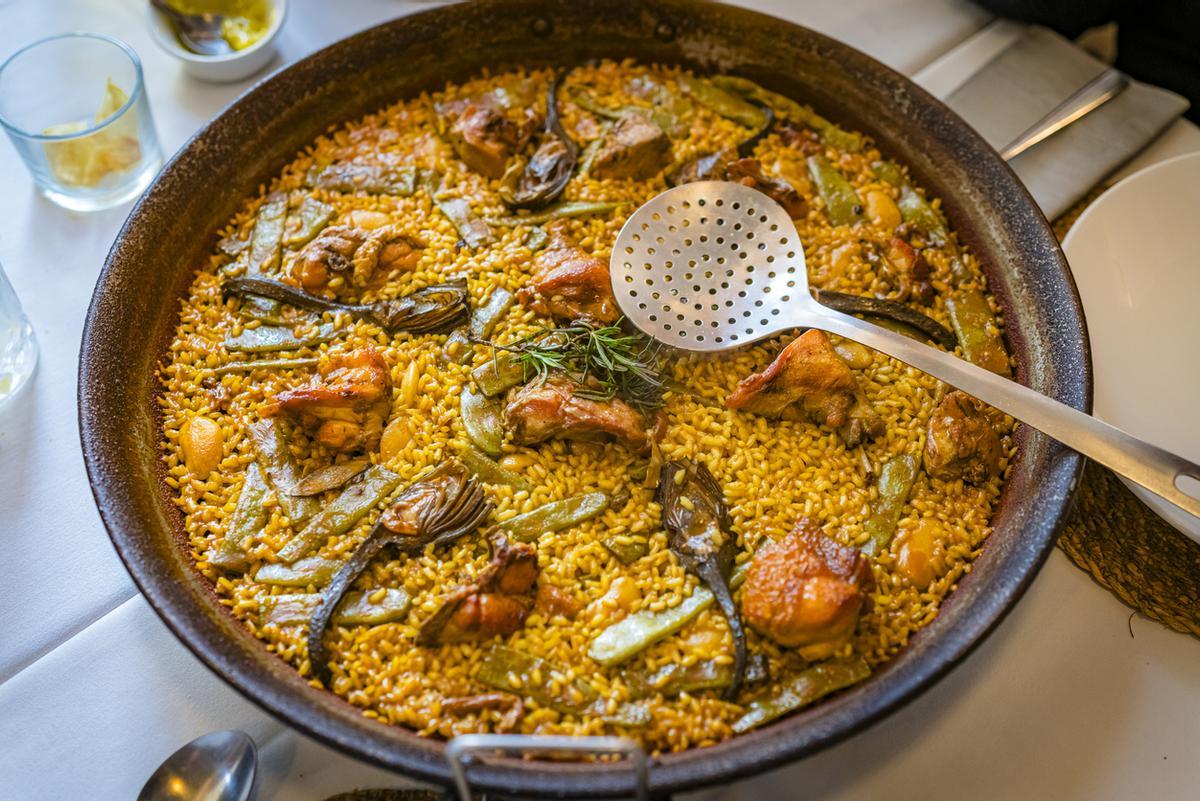 Paella española en una sartén tradicional disparada en una mesa de restaurante