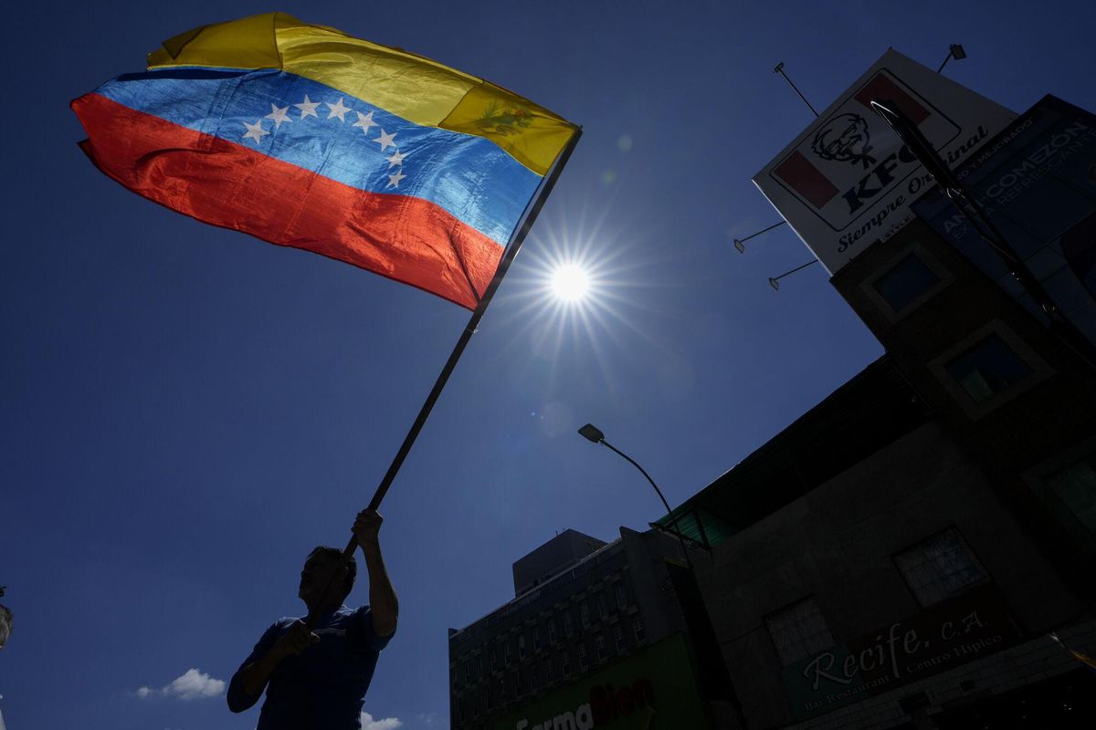 A man waves a flag during a protest by opponents of Venezuelan President Nicolas Maduro the day before his inauguration for a third term in Caracas, Venezuela, Thursday, Jan. 9, 2025. (AP Photo/Matias Delacroix)