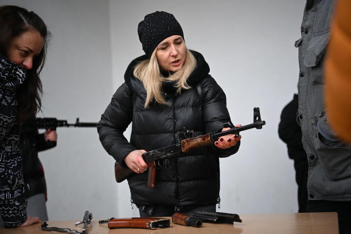 Una mujer aprende cómo usar un rifle de asalto AK-47 durante un curso de autodefensa para civiles celebrado a las afueras de Leópolis, en Ucrania.