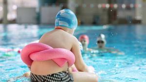 Archivo - Obesidad en la infancia. Niño con flotador sentado al borde de la piscina.