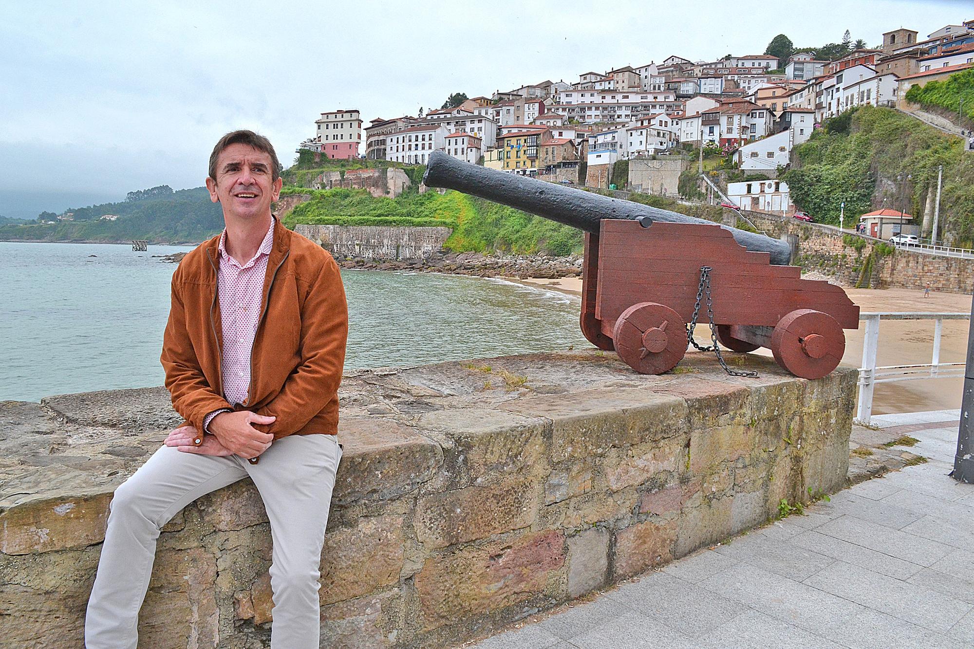César Fernández sentado en el puerto junto a uno de los cañones de la vieja fortaleza de El Castillo.