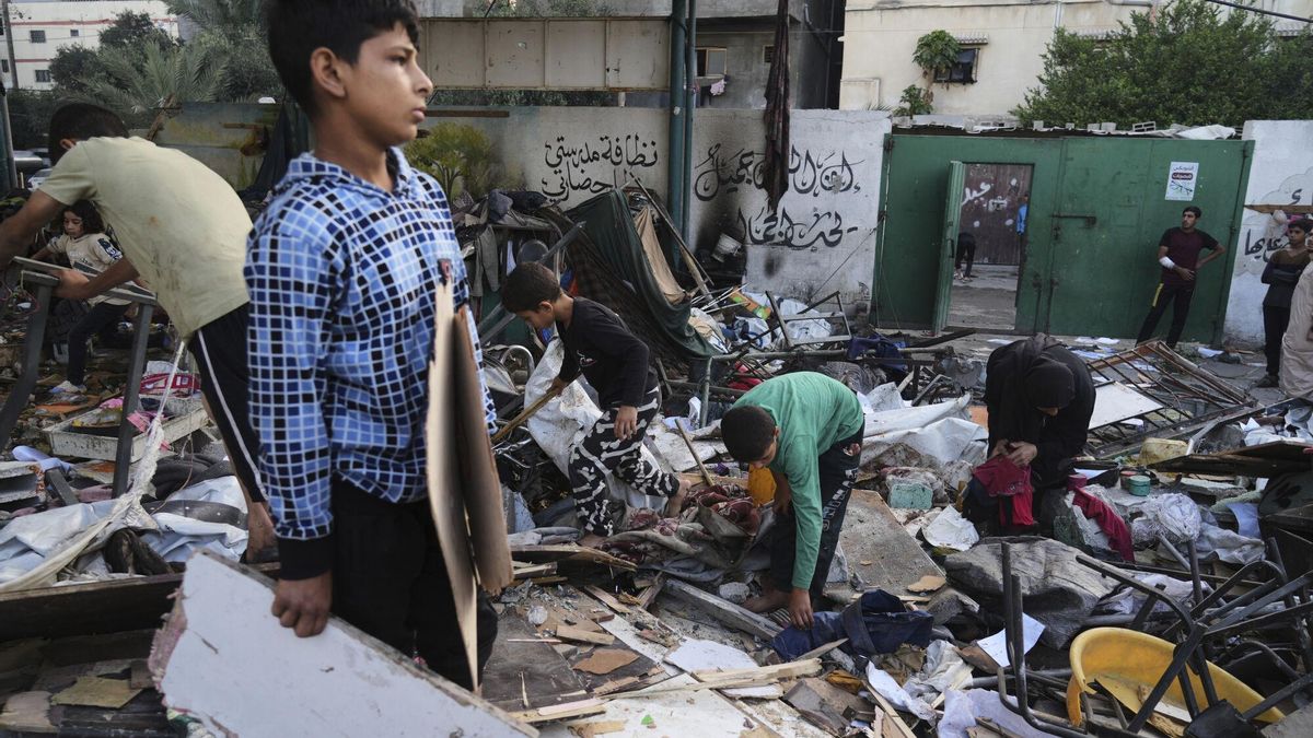 Palestinos inspeccionan los daños en una escuela que fue alcanzada en un mortífero ataque militar israelí en la ciudad de Gaza.