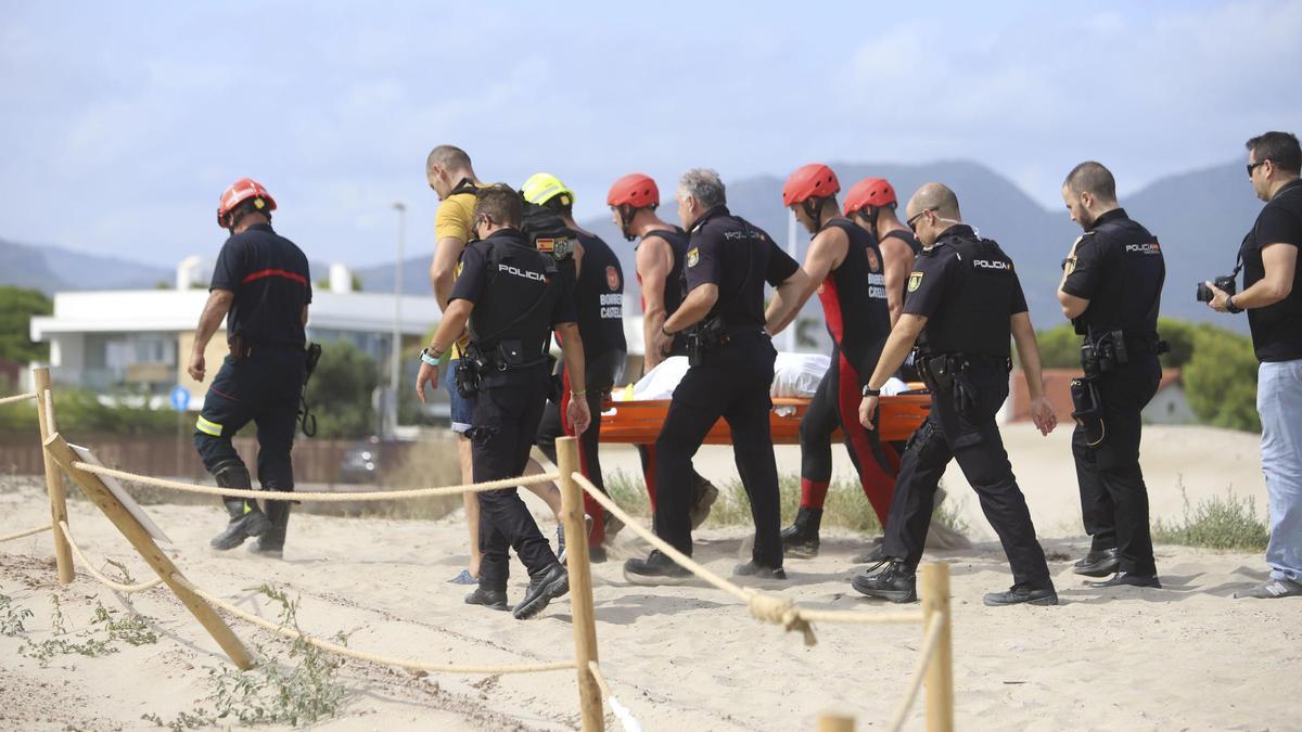 Policías y bomberos extraen a un hombre fallecido de una playa de Castelló.