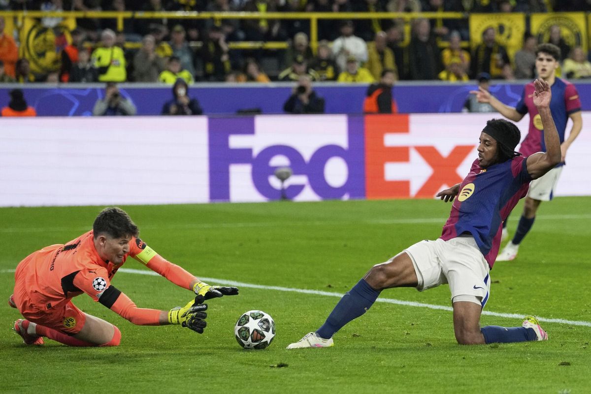 Dortmunds goalkeeper Gregor Kobel, left, makes a save in front of Barcelonas Jules Kounde during the Champions League quarterfinals second leg soccer match between Borussia Dortmund and Barcelona, at the Signa-Iduna Park in Dortmund, Germany, Tuesday, April 15, 2025. (AP Photo/Martin Meissner)