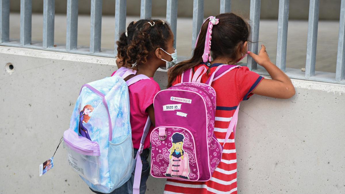 Dos niñas a las puertas de un colegio.