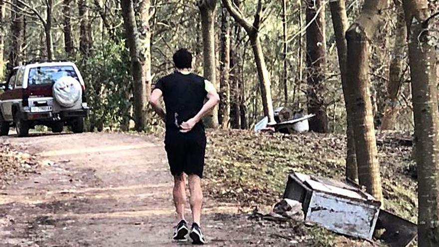 Un joven camina por el sendero plagado de residuos. |   // G.NÚÑEZ