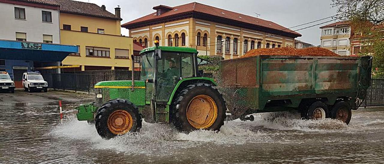 Un tractor pasa por una zona inundada por el río Linares. | Vicente Alonso