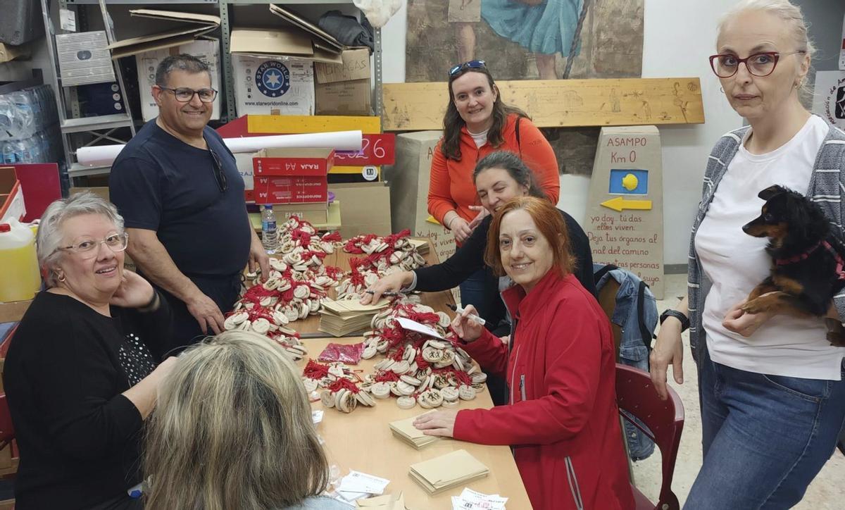 Voluntarios de Asampo, metiendo los dorsales de madera de avellano en sobres.