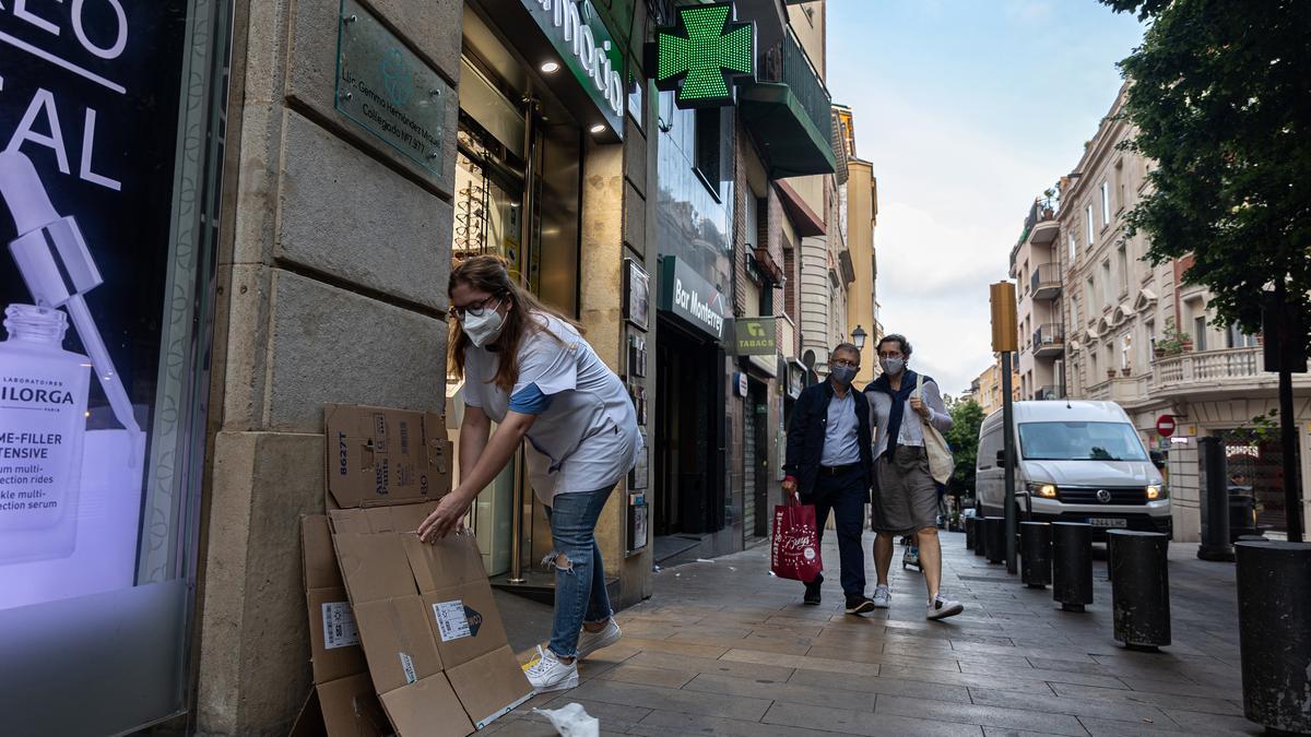 Día de sacar el cartón en Sarrià. Una farmacéutica de Major de Sarrià cumple con su cometido