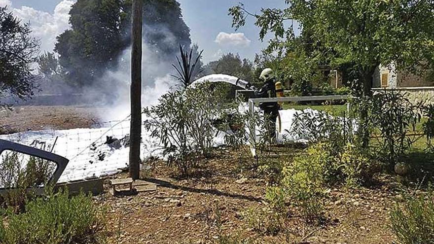 Un bombero de Mallorca apaga los restos de una de las aeronaves siniestradas ayer.