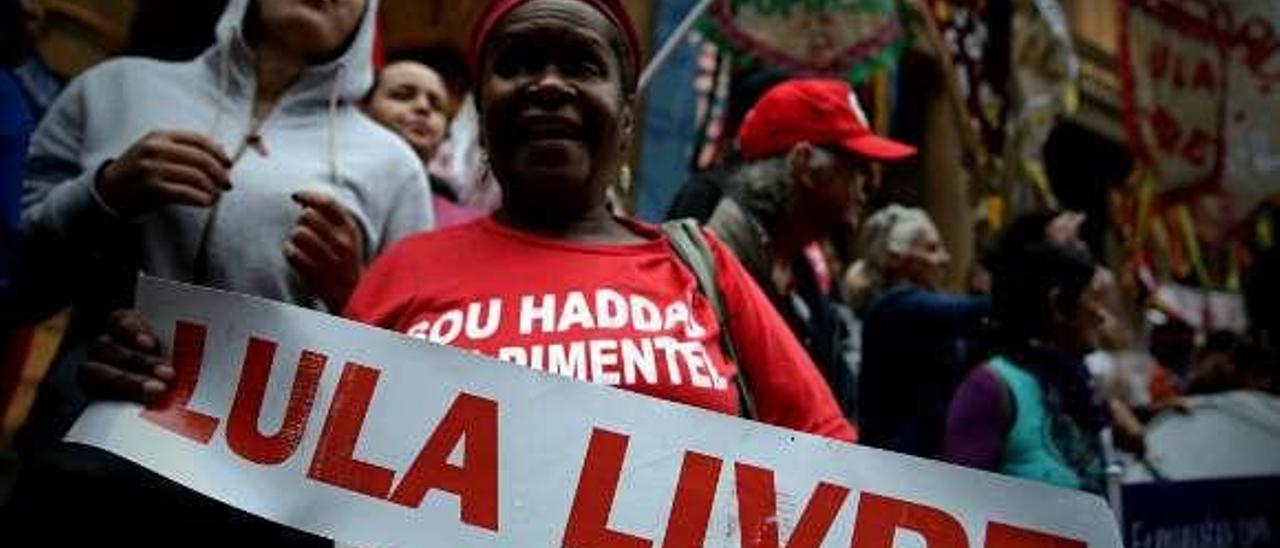 Una mujer con un cartel que reclama la libertad de Lula en un acto del PT.