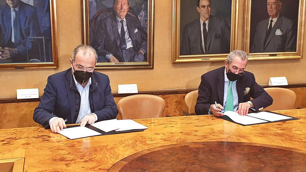 José Manuel Ferreira, a la izquierda, y Eduardo Sánchez Morrondo, ayer, firmando el convenio marco de colaboración de la Cámara de Comercio y Compromiso Asturias XXI. | LNE