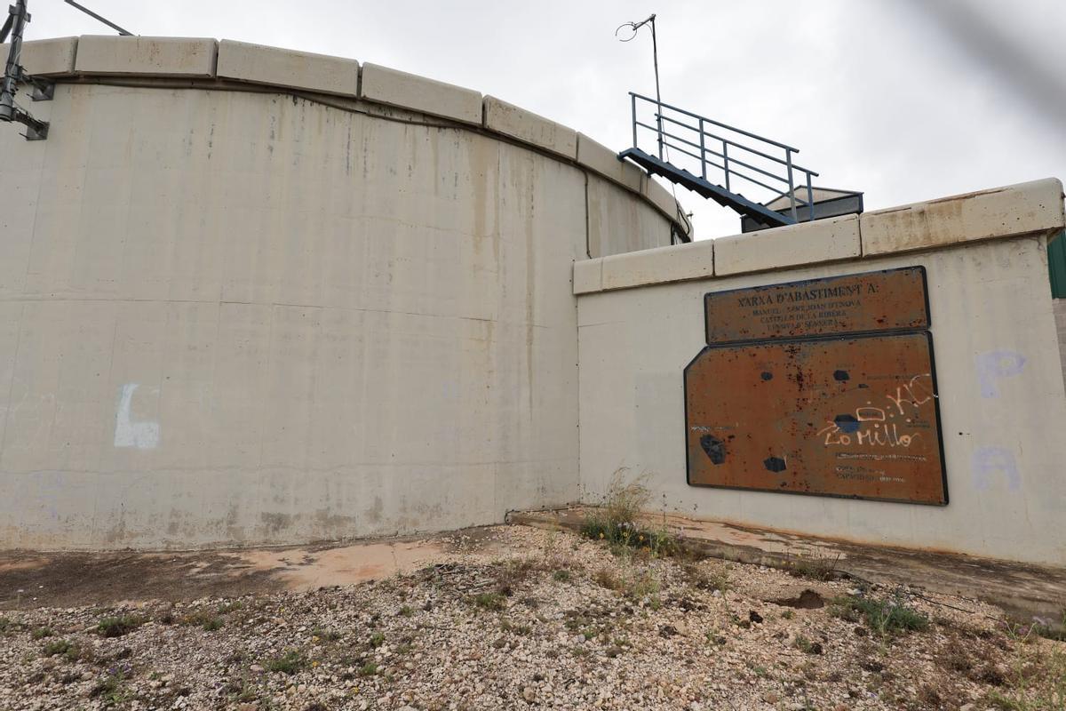 Tanque de agua y, junto a él, la placa de la inauguruación, con los cincos pueblos de la Mancomunitat.