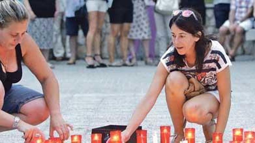 Dos jóvenes encienden velas en el acto celebrado en Sant Jordi en memoria de Gemma Vich.