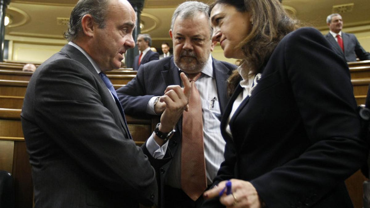 Guindos habla con la portavoz del PSOE, Soraya Rodríguez, en el Congreso.