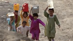 Niños afganos transportan agua en Kabul.