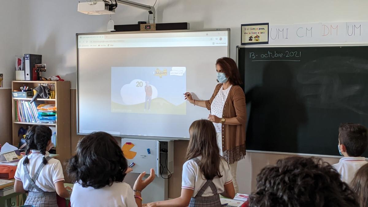 Una profesora de Primaria explica un contenido de forma virtual.