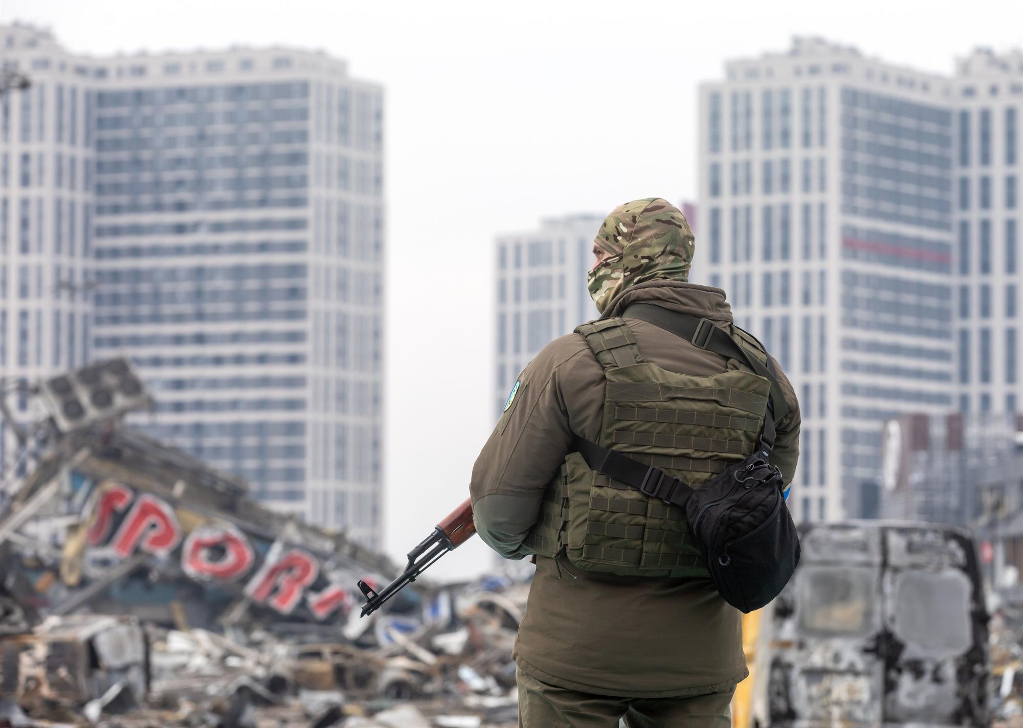 Un militar ucraniano junto a un centro comercial destruido en Kiev.