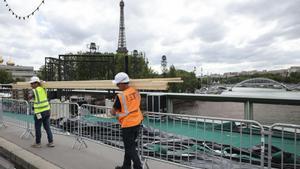 Varios operarios pasan ante el río Sena de París, el martes 23 de julio.