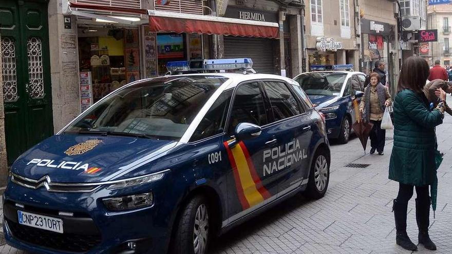 Coches de la Policía Nacional ante una serie de comercios en labores de prevención de robos. // R. Vázquez