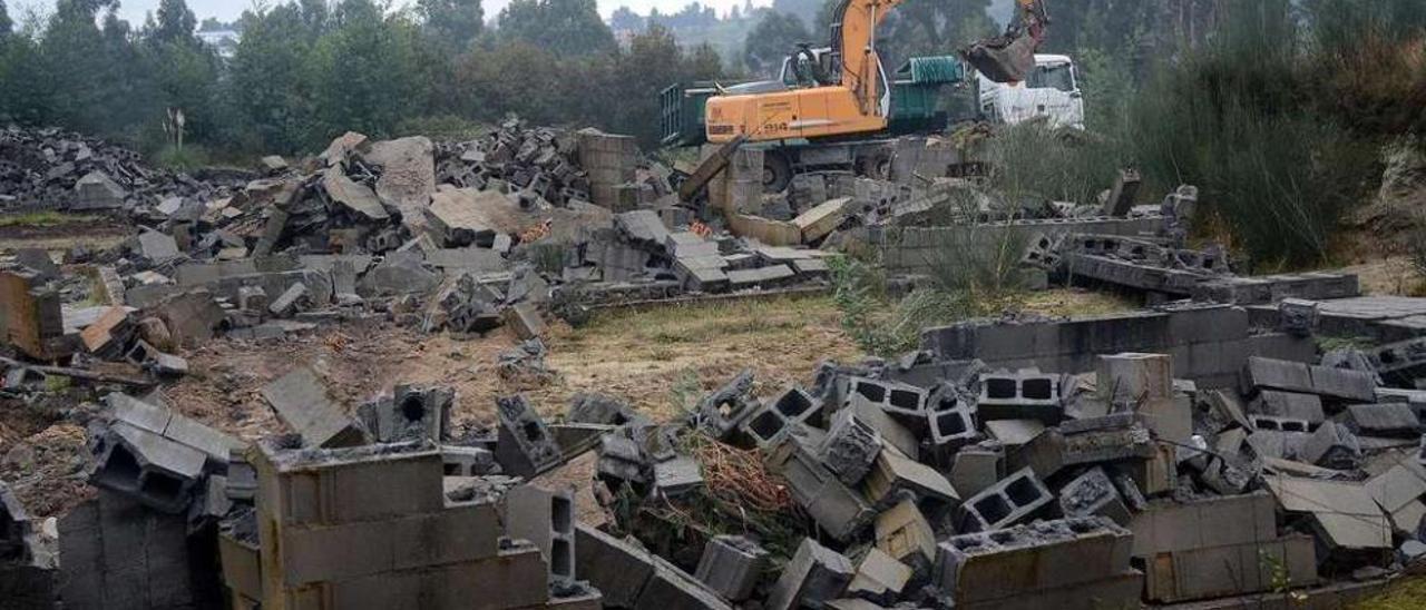 Las excavadoras desmontan las construcciones del poblado de entrenamiento. // R.V.