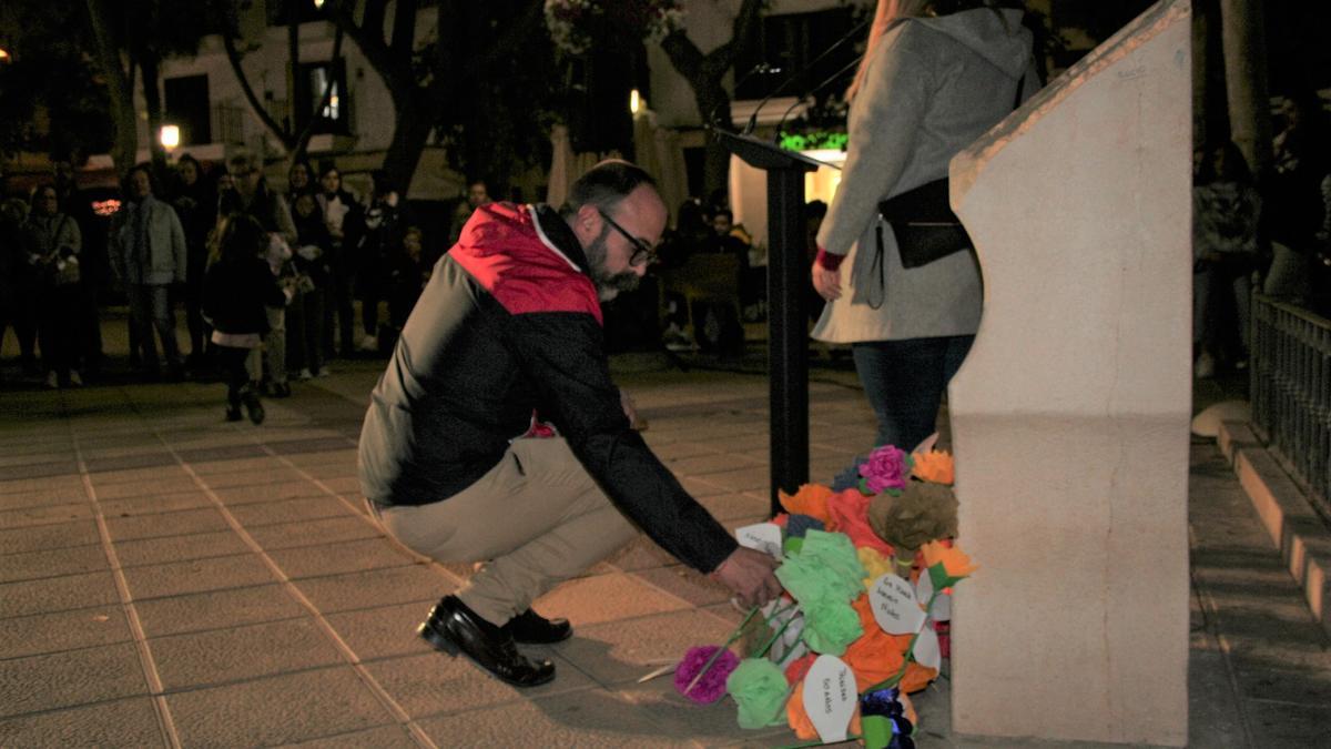 Enrique Olcina colocaba una flor de papel por una de las víctimas de la violencia machista ante el monolito que las recuerda en la Plaza de Calderón de la Barca.