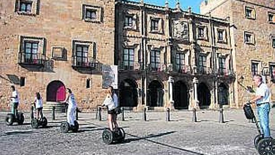 David Gómez y la familia Álvarez Noval en «segway» junto al palacio de Revillagigedo, camino del Cerro Santa Catalina y en la calle Marqués de San Esteban. / juan plaza