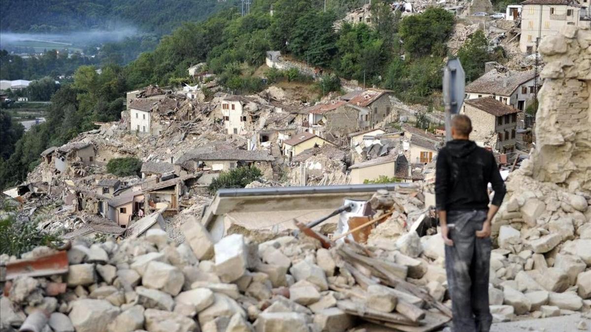 Un superviviente del terremoto mira las ruinas de Pescara del Tronto