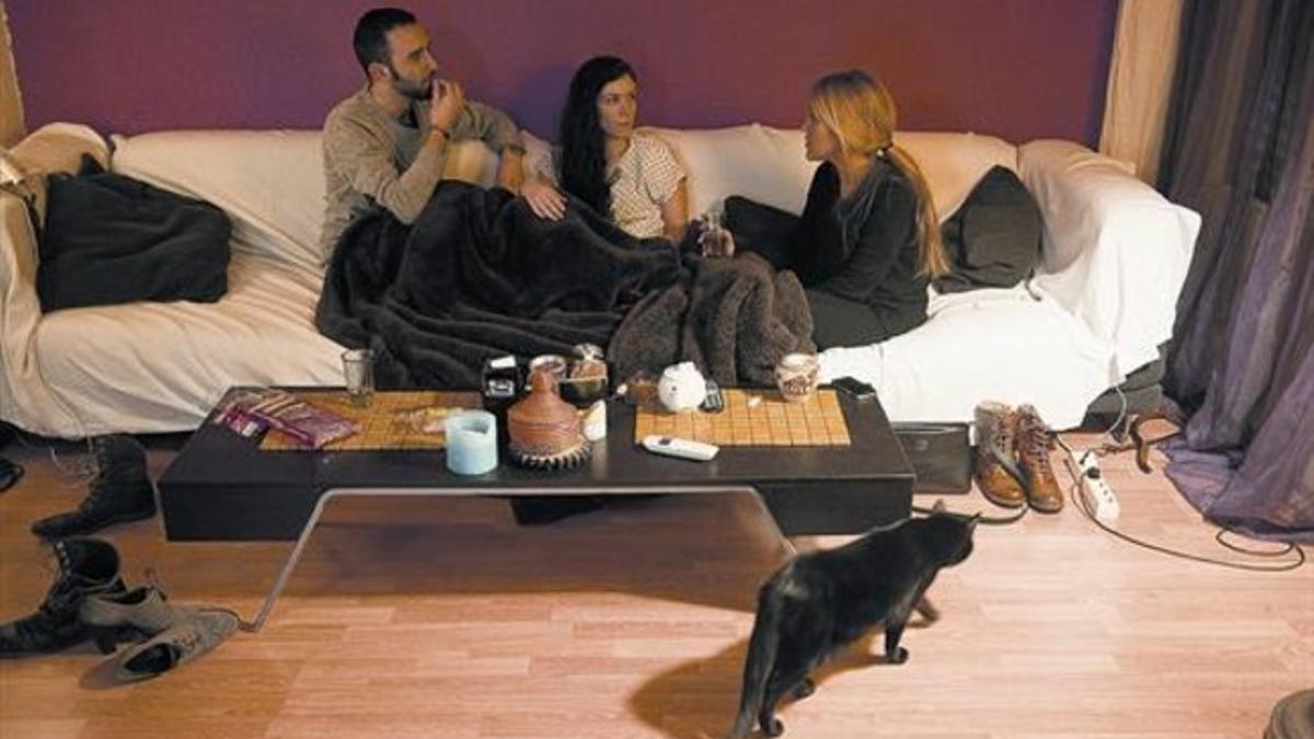 Silvia, con unos amigos, en el salón del piso de Ciutat Vella que comparte con Víctor.
